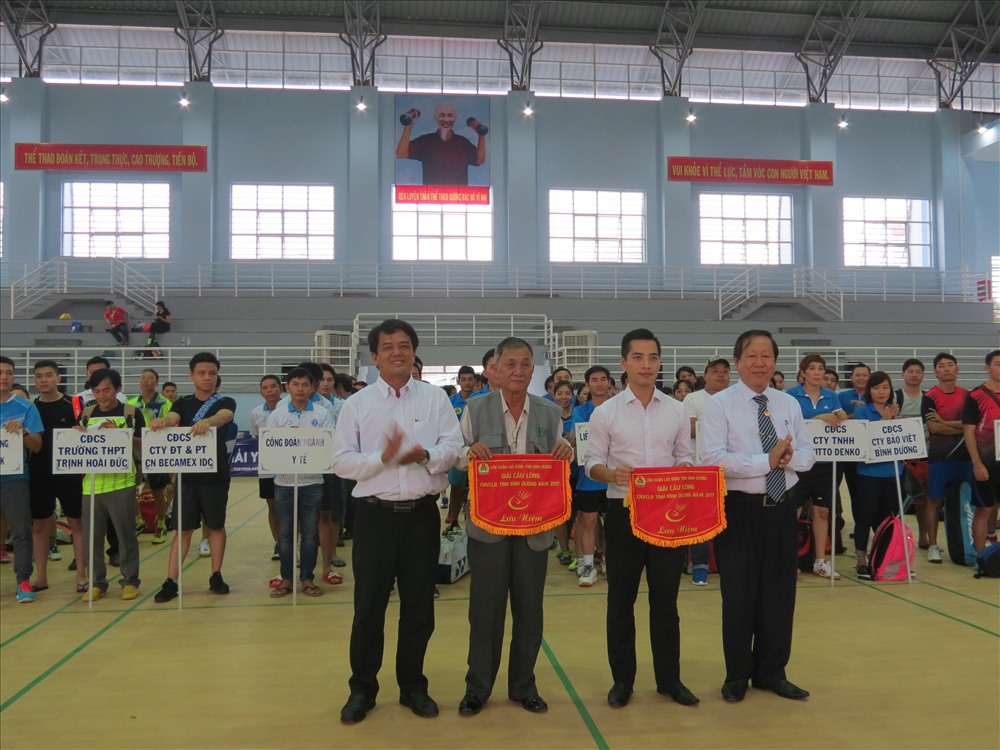 Chủ tịch LĐLĐ tỉnh Bình Dương Bùi Thanh Nhân (trái ảnh) và ông Nguyễn Thiện Phước trao cờ lưu niệm cho hai đơn vị tài trợ giải - Ảnh: L.T