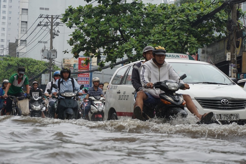 Đường Nguyễn Xí tại khu vực từ giao lộ với đường Đinh Bộ Lĩnh tới gần cầu Đỏ, nước ngập hơn nửa bánh xe khiến hàng loạt phương tiện chết máy phải dắt bộ.