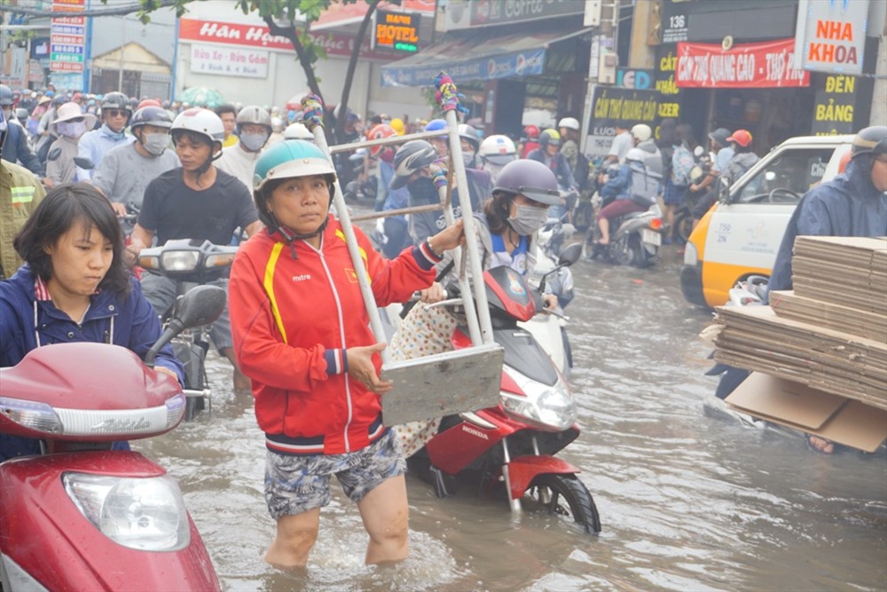 Người dân bì bõm lội nước trên đường Nguyễn Xí.