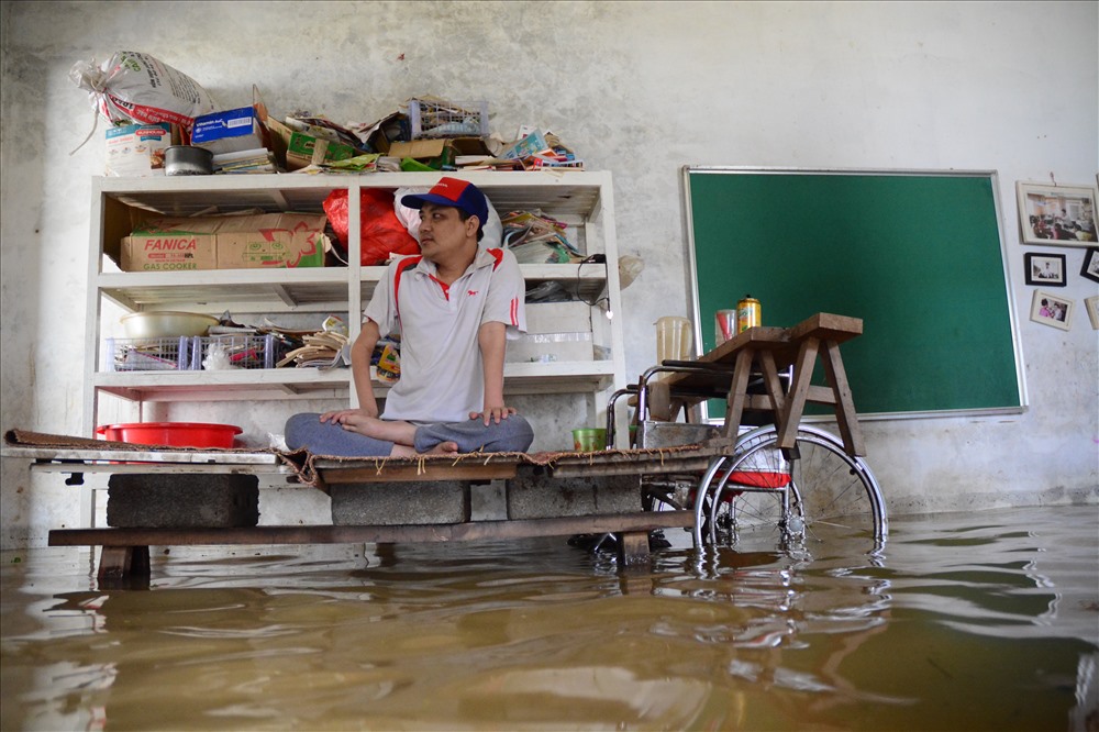 Thầy giáo Phùng Văn Trường (khuyết tật cả chân và tay) “mắc kẹt” trong chính ngôi nhà của mình bởi dòng nước lũ đã hơn 3 ngày nay.