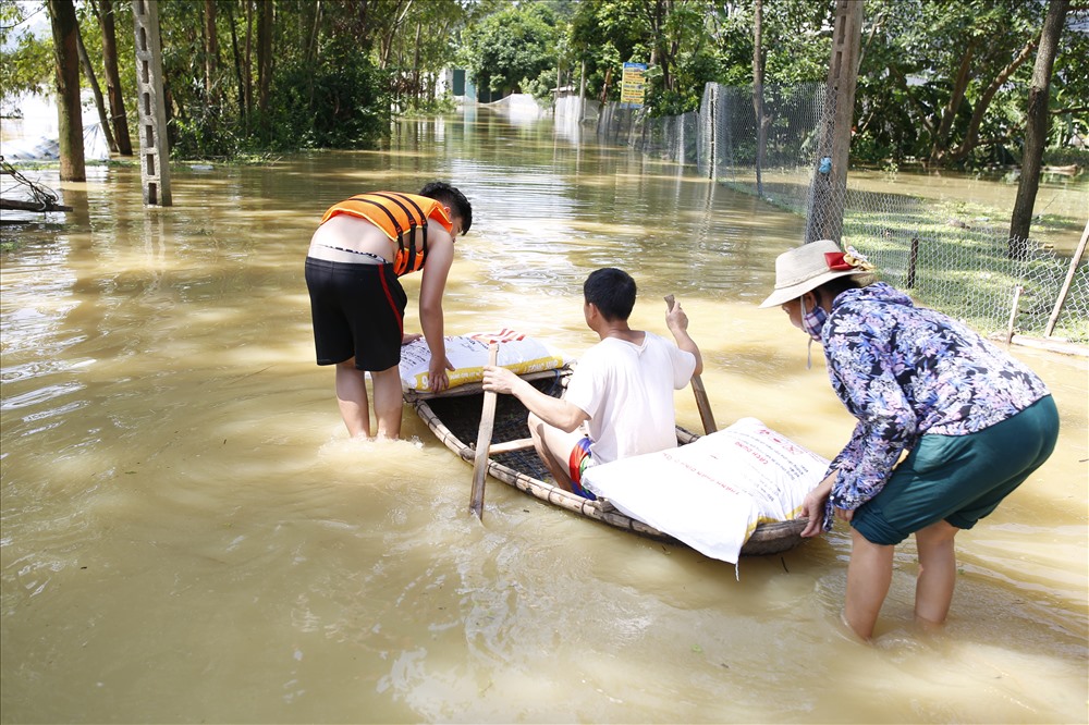 Do mọi ngả đường vào thôn bị nước nhấn chìm nên người dân phải vận chuyển đồ cứu trợ bằng thuyền.