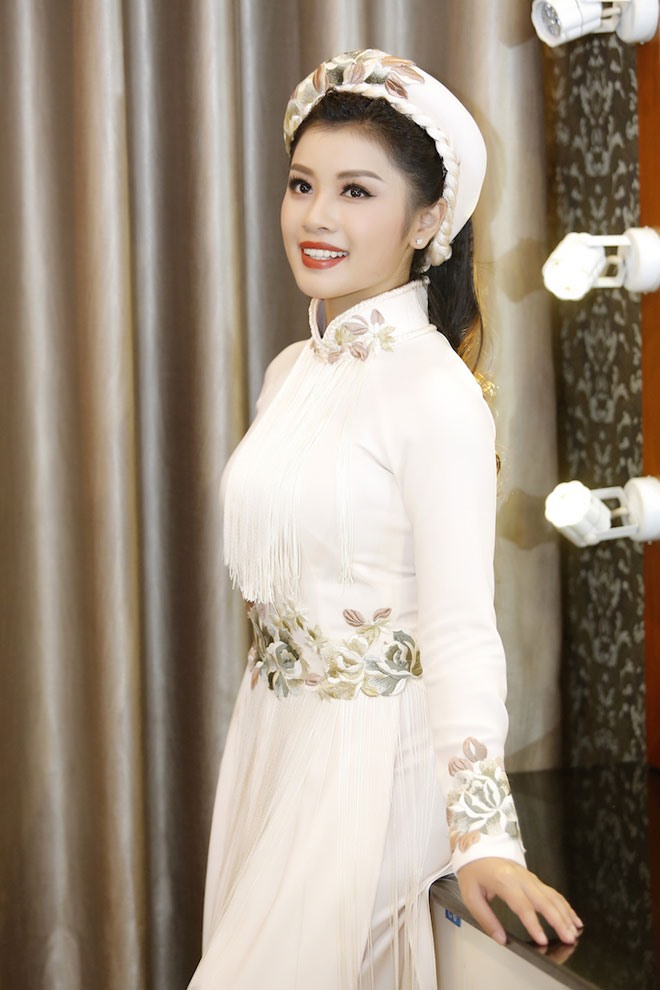 Set đồ với áo dài và mấn đội giúp hình ảnh Nguyễn Thu Hằng lộng lẫy và uy quyền như một quý phi, khoe được tối đa vẻ đẹp yêu kiều, sang trọng của cô gái trẻ.