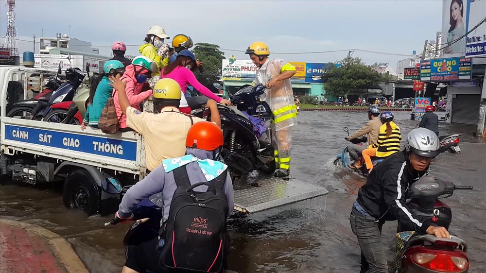 CSGT dùng xe “cõng” người dân qua vòng xoay An Lạc ngập sâu.