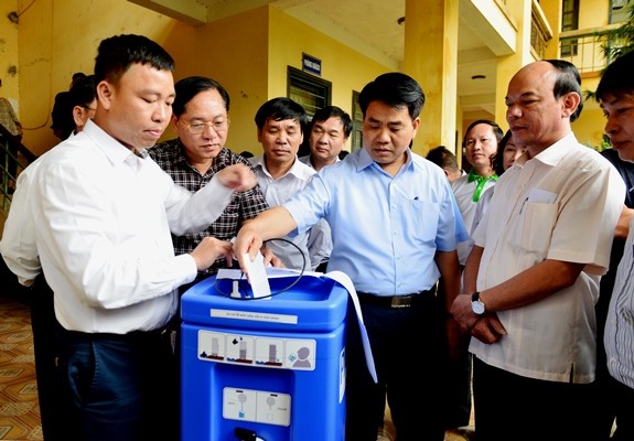 Chủ tịch UBND TP Nguyễn Đức Chung kiểm tra máy lọc nước tặng người dân vùng lũ. Ảnh hanoi.gov.vn