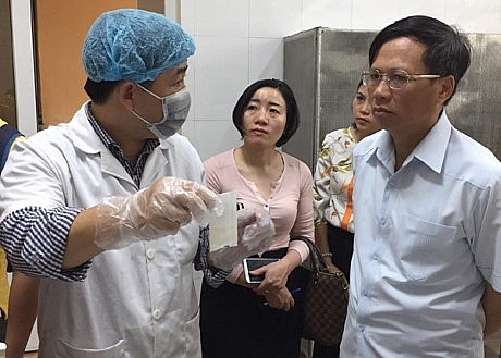 Phó Chủ tịch UBND quận Hoàng Mai Trần Quý Thái (bên phải) trong một cuộc kiểm tra xét nghiệm thực phẩm. (Ảnh: Báo Kinh tế Đô thị).