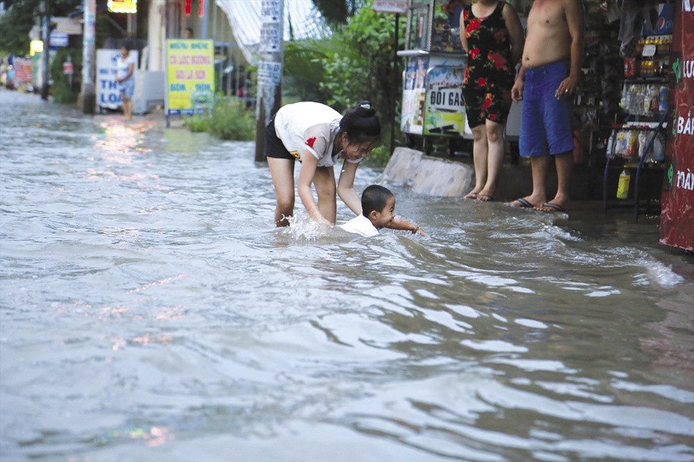 Trẻ nhỏ đi học về bị vấp ngã giữa dòng nước mênh mông - Ảnh: Ngọc Tiến