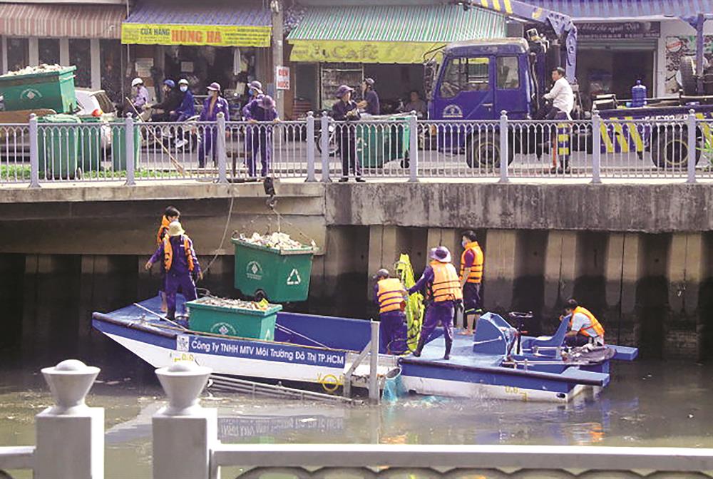 Công nhân Công ty TNHH MTV Môi trường - Đô thị TP HCM đang vớt rác làm sạch dòng kênh Nhiêu Lộc - Thị Nghè. Ảnh: H.H