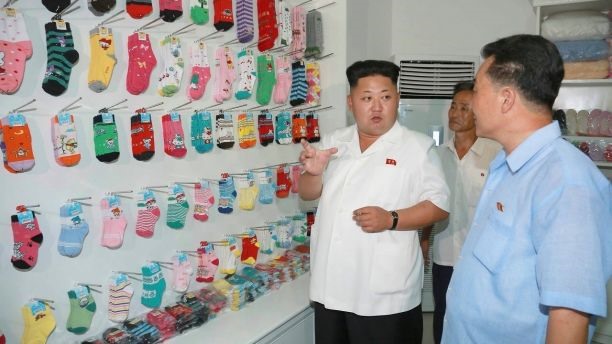 Ông Kim Jong-un trò chuyện khi đến thăm nhà máy dệt kim Bình Nhưỡng, tháng 8.2014. Ảnh: KCNA/Reuters