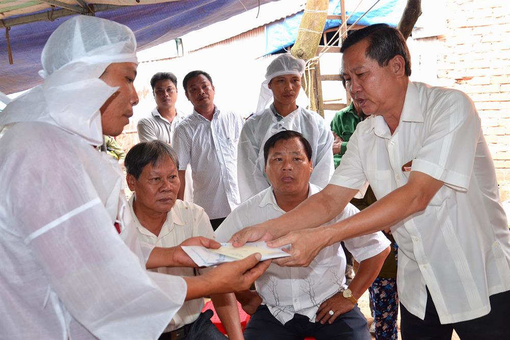 Phó chủ tịch UBND tỉnh An Giang Lê Văn Nưng trao tiền cho gia đình các nạn nhân.