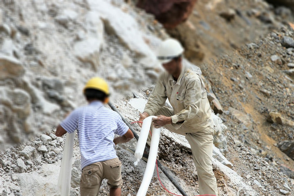 Những thợ đá nhồi từng túi thuốc nổ lớn vào để chuẩn bị phá núi. Ảnh: P.V