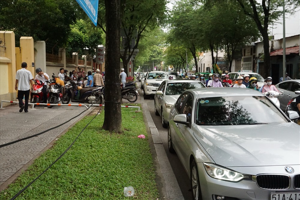 Phụ huynh đậu xe ô tô trên đường Nguyễn Bỉnh Khiêm (Q.1) chờ đón con gây cản trở giao thông.  Ảnh: M.Q