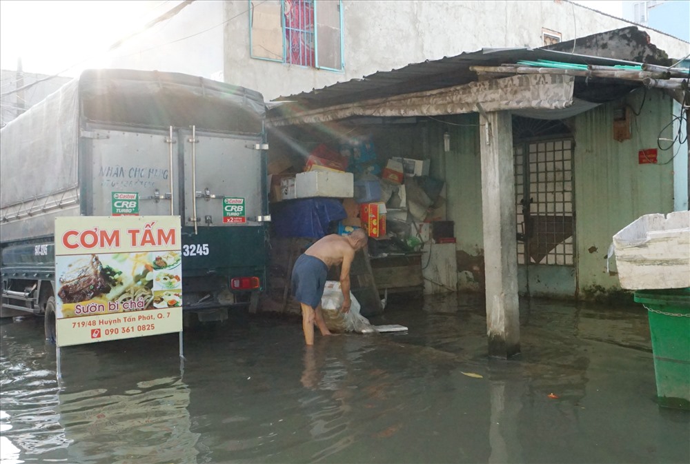 Nước ngập sâu tại một con hẻm trên đường Huỳnh Tấn Phát khiến sinh hoạt của người dân rất khổ sở.  Ảnh: M.Q