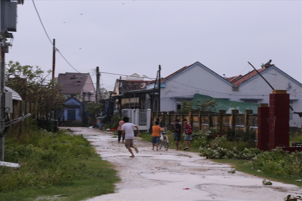 Sau bão, trẻ con trong xã lại chơi đùa cạnh những ngôi nhà bong tróc do bão gây ra. Ảnh: H.L