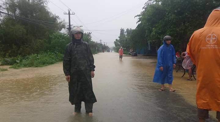 Tuyến đường qua thôn Nông Sơn xã Điện Phước bị nước lũ chia cắt. Chính quyền địa phương cử người túc trực hướng dẫn giao thông. Ảnh: LP