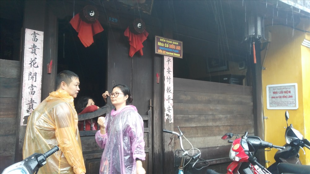 Hai du khách người Hàn trò chuyện với chủ một ngôi nhà cổ sau bậu cửa. Họ là du khách hiếm hoi không quan tâm chuyện lụt lội. Ảnh: H.V.M