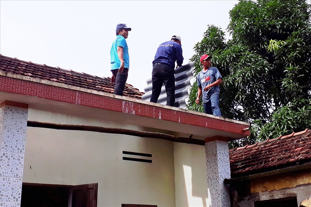 Các tình nguyện viên sửa nhà bị thiệt hại do lốc xoáy cho bà con xã đảo Tam Hải. Ảnh: LP