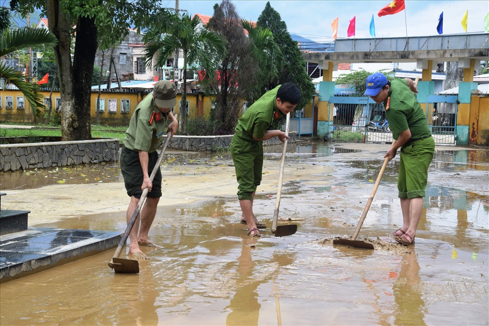 Lực lượng công an tỉnh Quảng Nam vượt lũ về vùng rốn lũ Đại Lộc dọn vệ sinh giúp dân. Ảnh: LP