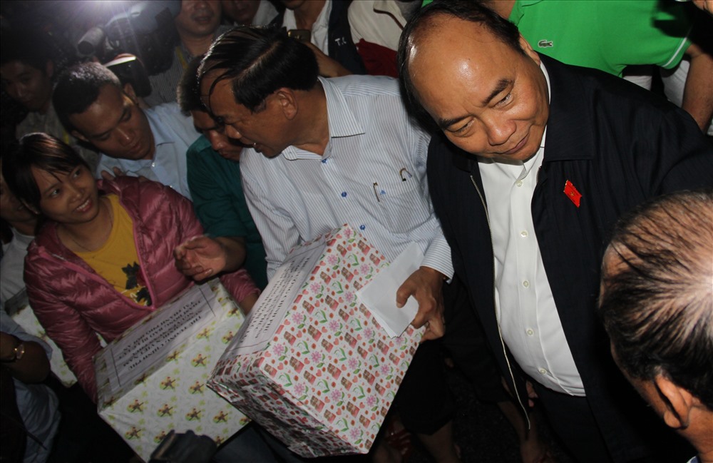 Thủ tướng Nguyễn Xuân Phúc tặng quà và thăm hỏi người dân có nhà bị ngập lụt tại Hội An. Ảnh: L.T