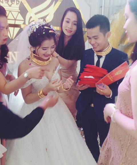 Cô dâu chú rể người đeo đầy vàng, tay cầm sổ đỏ tại buổi cưới (ảnh facebook)