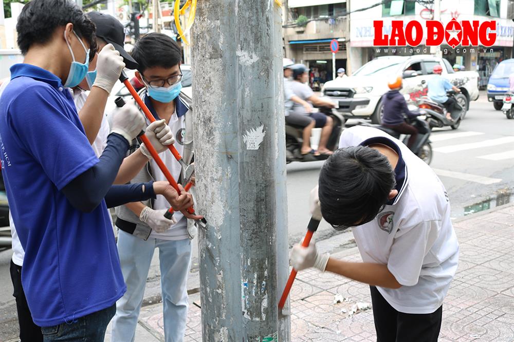 Các bạn sinh viên trường ĐH Tài nguyên-Môi trường TPHCM đang làm sạch trụ điện trên đường Lê Văn Sỹ (phường 1, quận Tân Bình) trước khi vẽ tranh. Ảnh: Đoàn phường 1 Tân Bình