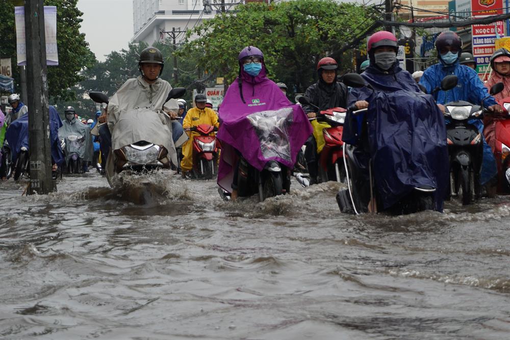Đường Nguyễn Xí (Q.Bình Thạnh) nước ngập hơn nửa bánh xe khiến hàng ngàn người chạy xe máy qua đây khốn đốn. 
