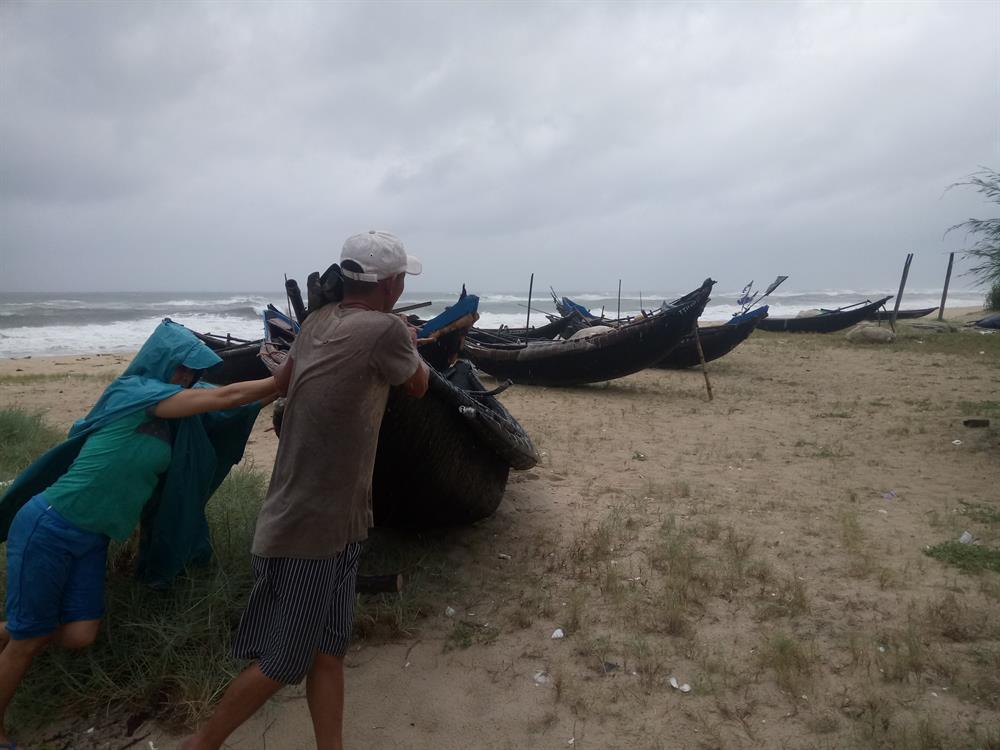 Người dân vùng biển bãi ngang huyện Phú Vang đưa tàu thuyền lên bờ, sẵn sàng chống chọi với mưa bão. Ảnh: NĐT