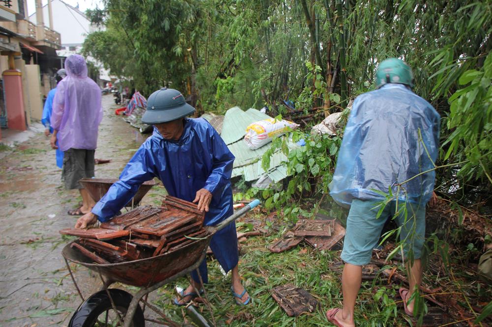 Những người dân này đang thu gom ngói mà bão thổi bay để sửa chữa nhà.