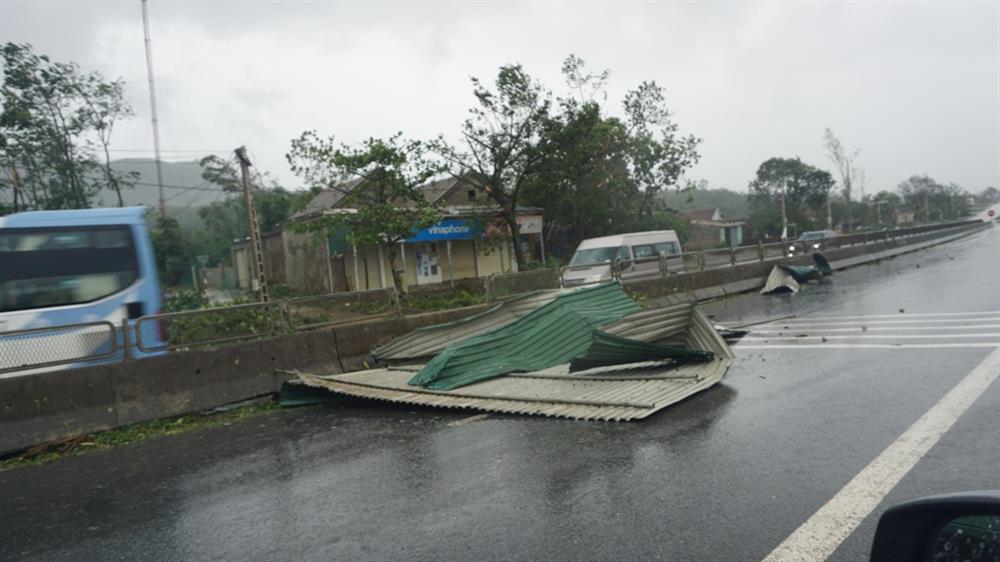 Gió lớn “bốc” một mái tôn bay ra mặt đường quốc lộ 1A. Ảnh: Quang Đại