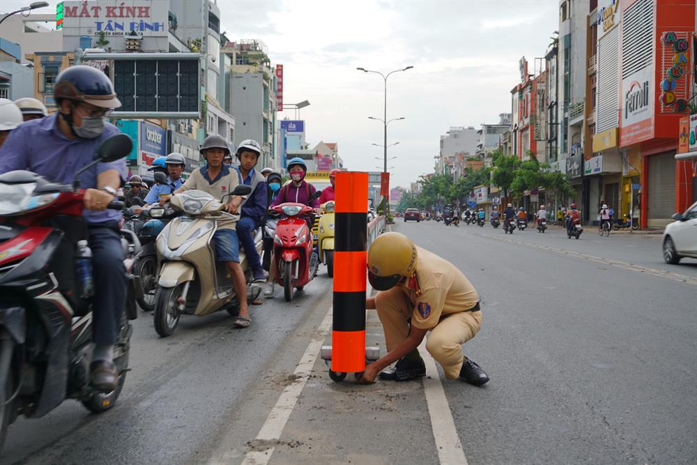 CSGT đi chuyển dải phân cách để mở rộng đường cho các phương tiện lưu thông lên cầu vượt Hoàng Hoa Thám.