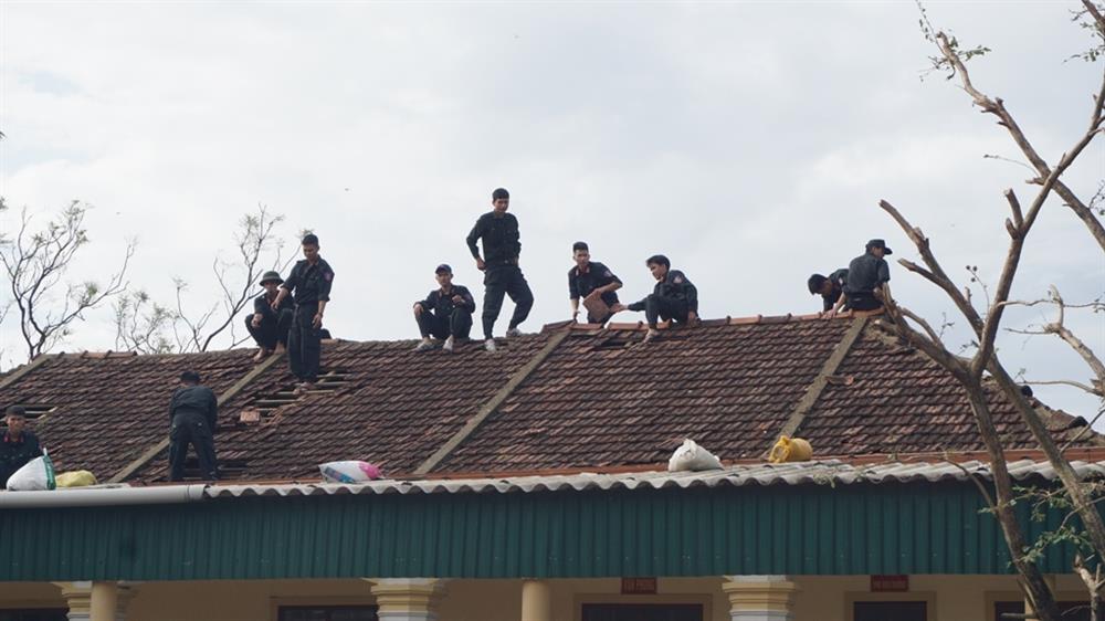 Lực lượng vũ trang lợp lại mái ngói trường THCS Kỳ Nam. Ảnh: QĐ
