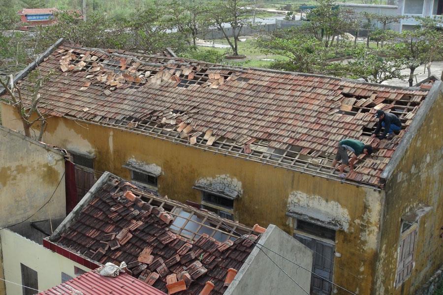 Mái nhà của Trường mầm non xã Quảng Đông (Quảng Trạch, Quảng Bình) bị gió bão thổi bay hoàn toàn đang được lợp lại. Ảnh: LÊ PHI LONG