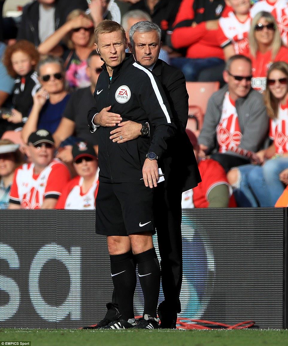 HLV Mourinho ôm chặt trọng tài thứ tư trước khi bị trọng tài chính đuổi lên khán đài. Ảnh: Empics Sport.