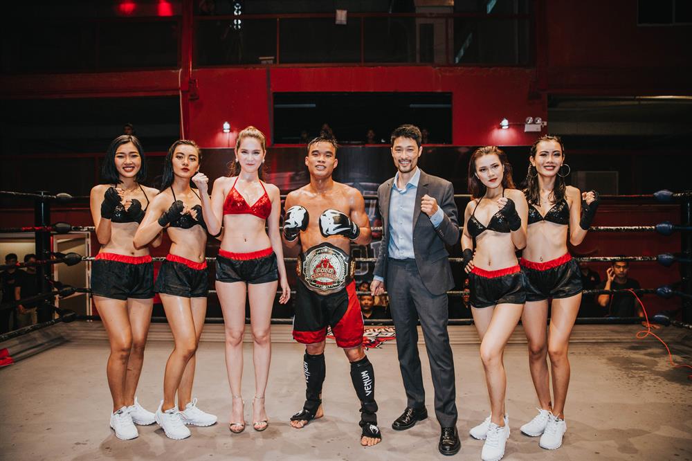Tổng đạo diễn chương trình - Johnny Trí Nguyễn tận tình đeo đai cho nhà vô địch đầu tiên của hạng MIDDLEWEIGHT 62kg là Vũ Lê Văn.