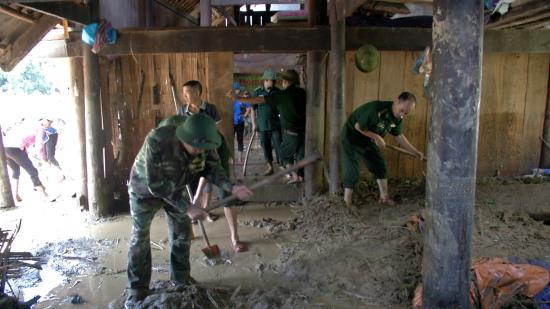 BĐBP Lào Cai giúp dân dọn dẹp đất đá tràn vào nhà dân.
