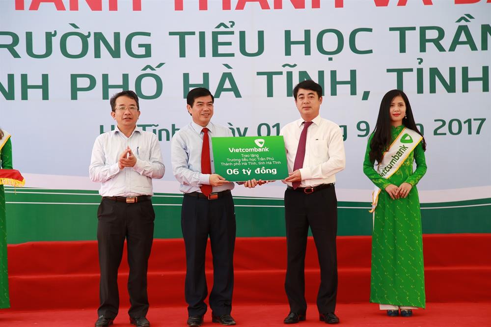 Ông Nghiêm Xuân Thành – Chủ tịch HĐQT Vietcombank (thứ 2 từ phải sang) trao tượng trưng số tiền 6 tỷ đồng của Vietcombank tài trợ kinh phí xây dựng Trường tiểu học Trần Phú (Hà Tĩnh)