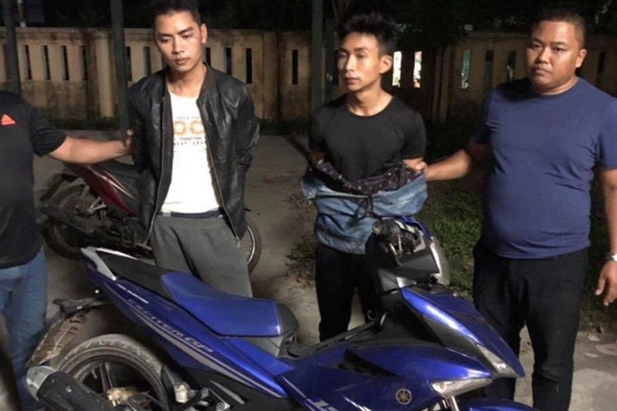 2 nghi phạm Đinh Văn Trường và Đinh Văn Giáp (từ trái qua) cùng tang vật là chiếc xe máy của nam sinh S.