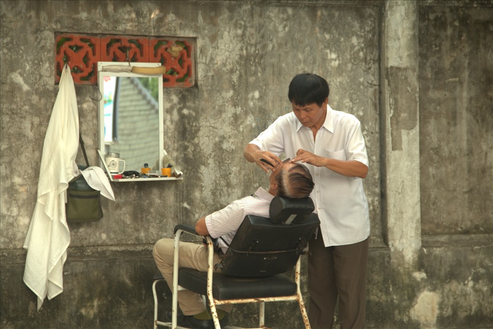 Ngoài 60 tuổi nhưng ông Phạm Mạnh Khải luôn miệt mài công việc cắt tóc của mình tại vỉa hè đường Kim Mã. Ông đã làm công việc này được 4 năm.