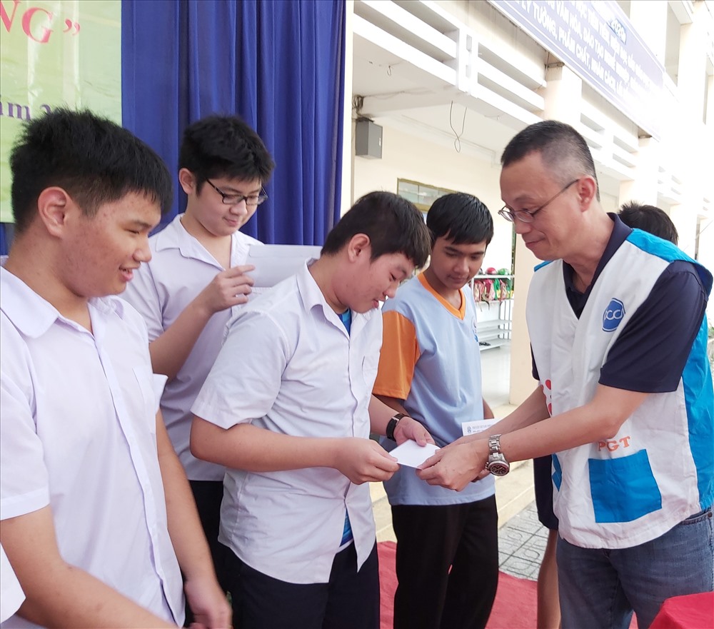 Đại diện Cty PouYuen Việt Nam tặng quà cho các em học sinh. Ảnh Nam Dương