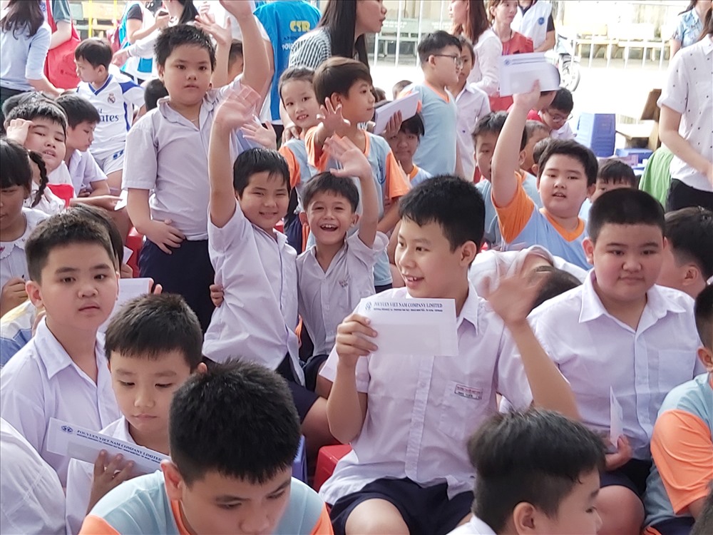 Niềm vui của các em học sinh khi nhận được quà tặng từ Cty PouYuen Việt Nam. Ảnh Nam Dương
