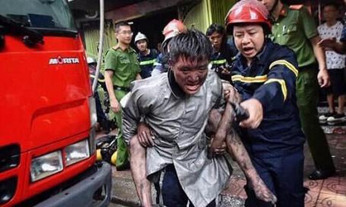 Hình ảnh chiến sỹ Cảnh sát PCCC mặt đen nhẻm vì khói, cõng người bị nạn lao ra khỏi đám cháy tại phố Núi Trúc (Ba Đình, Hà Nội) khiến cộng đồng xúc động, cảm phục. (Ảnh: Công an thành phố Hà Nội).