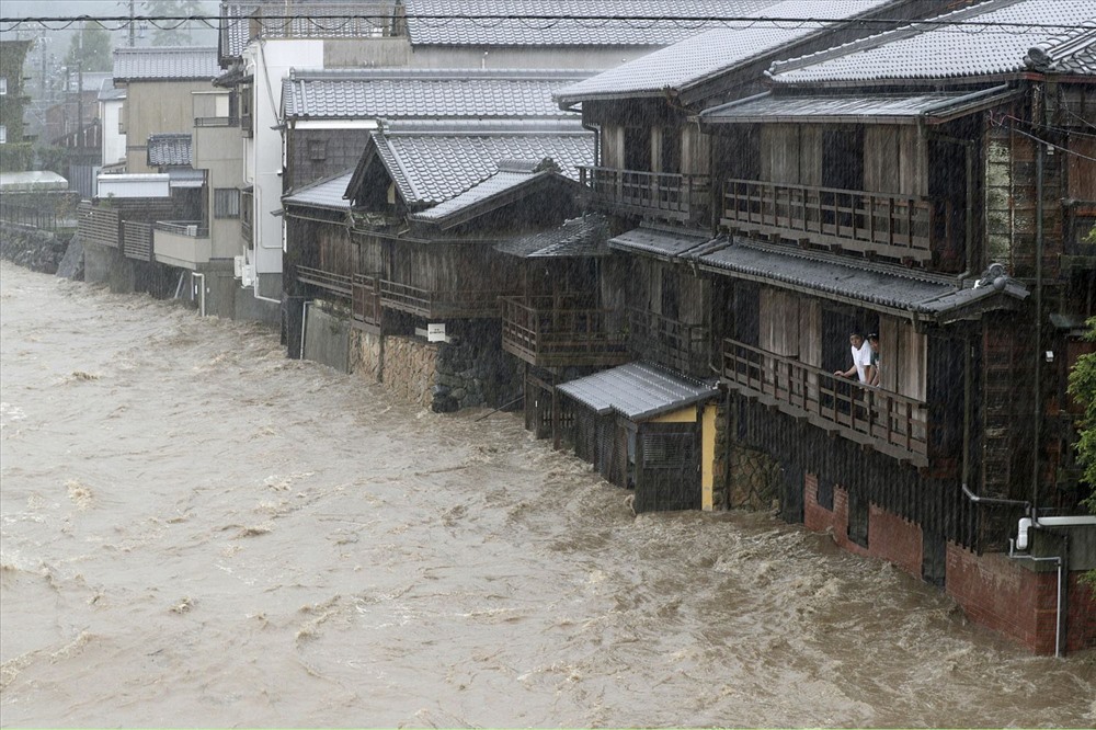 Hai nam giới quan sát nước sông Isuzu dâng lên do mưa lớn ảnh hưởng bởi siêu bão Hagibis ở Ise, miền trung Nhật Bản. Ảnh: Kyodo.