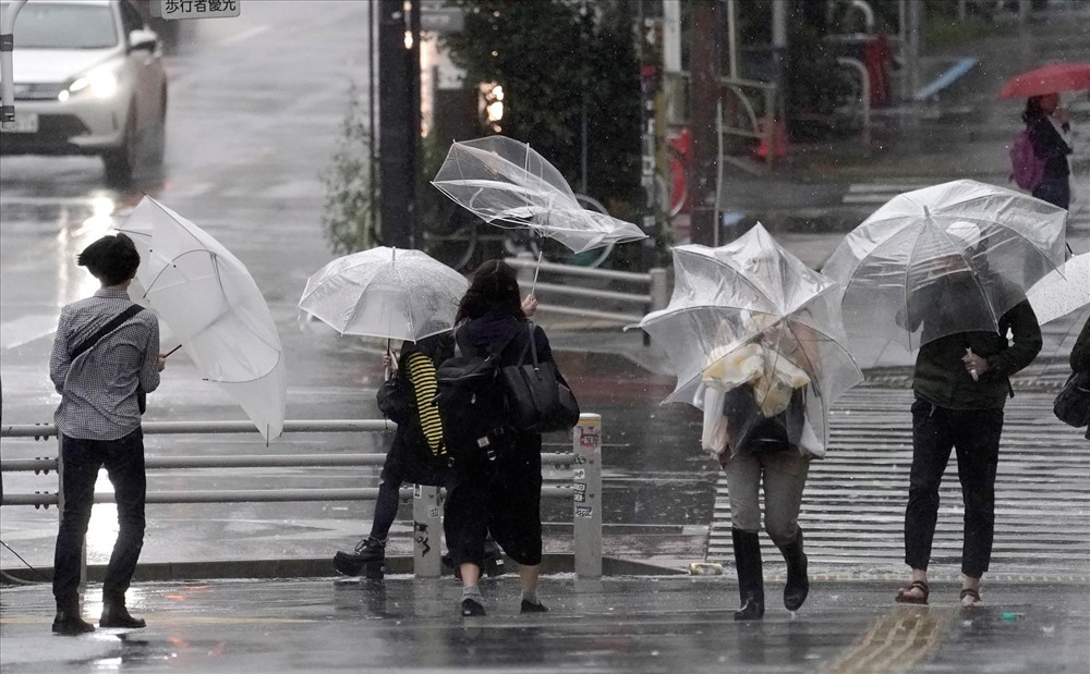 Người dân vật lộn với gió lớn ở Tokyo. Ảnh: EPA