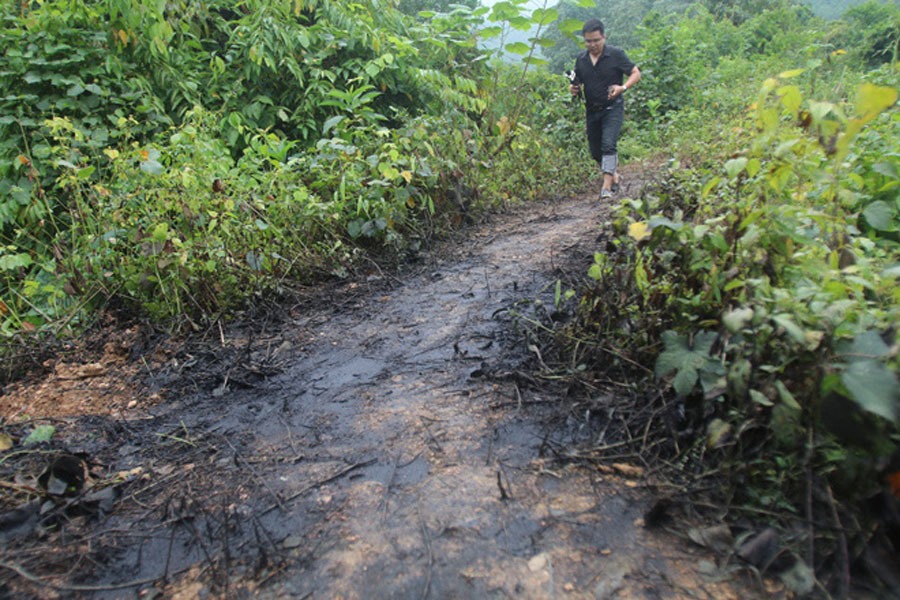 Đường dẫn ra suối Khại - một trong những nguồn cấp nước cho Nhà máy nước sông Đà (tỉnh Hòa Bình) và sau đó thành nước sinh hoạt cho thành phố Hà Nội - trơn trượt bởi dầu thải. Ảnh: TTXVN