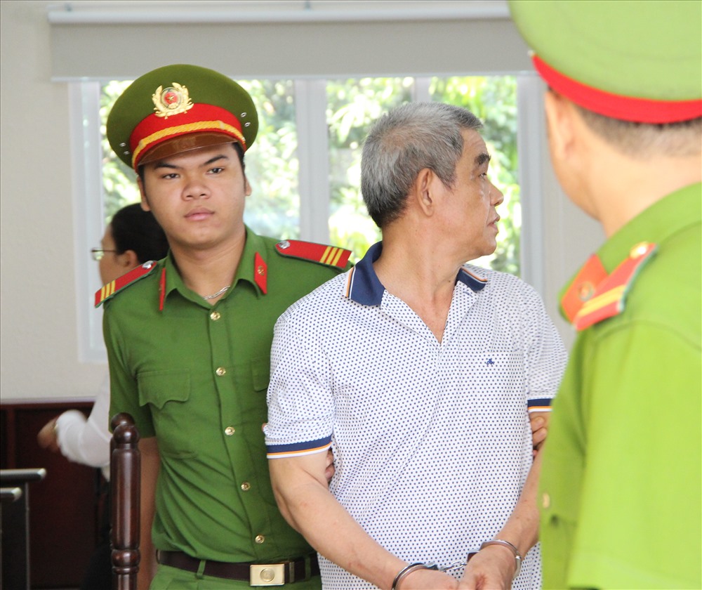 Bị cáo ngoái nhìn người thân khi được dẫn giải ra khỏi tòa án - Ảnh: Đình Trọng