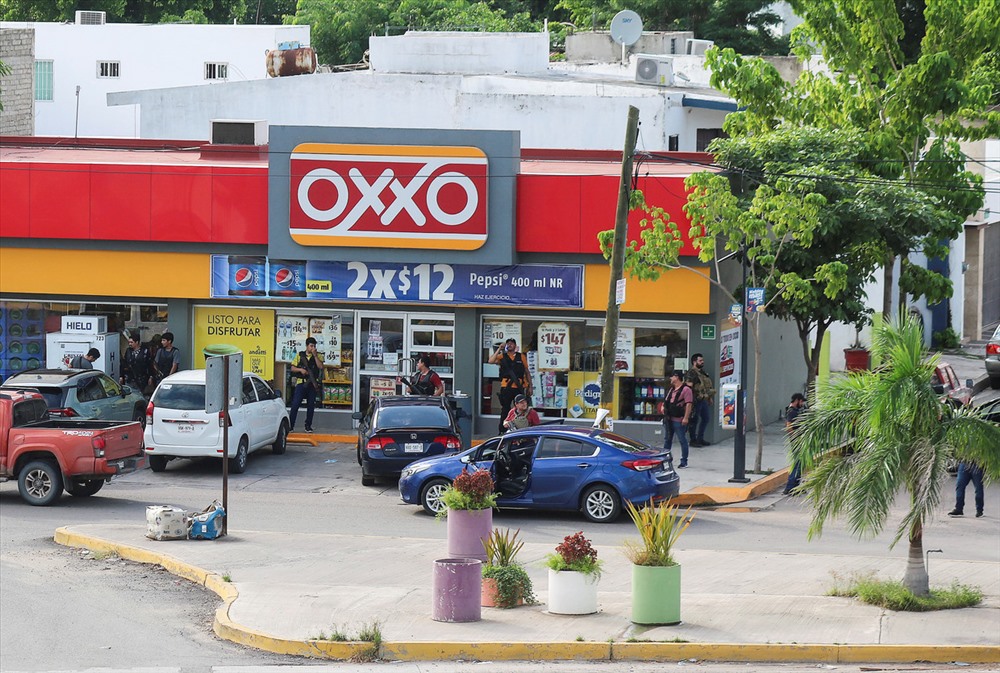 Các tay súng của băng đảng ma túy bên ngoài một cửa hàng trong cuộc đọ súng với lực lượng liên bang Mexico bắt giữ con trai trùm ma túy El Chapo. Ảnh: Reuters.