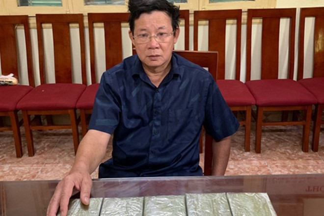 Ông Hồ Xuân Long - cựu giáo viên tại Nghệ An và 5 bánh heroin mà người này chuyển từ Nghệ An ra Hà Nội. Ảnh: CA