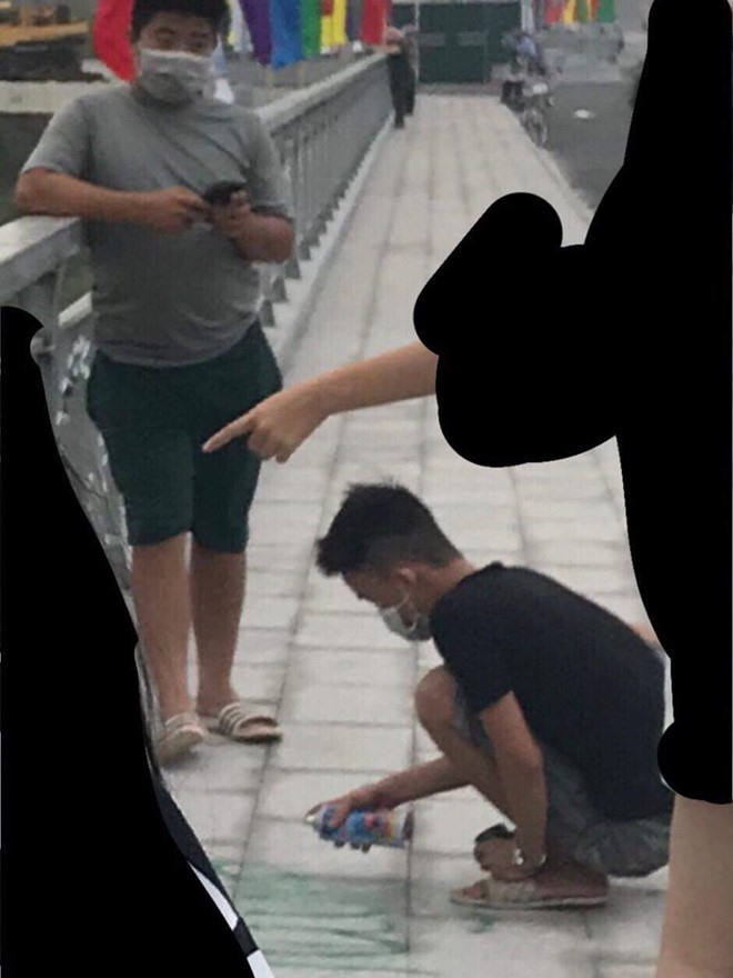 Hình ảnh nam thanh niên dùng bình sơn vẽ lên cầu Hoàng Văn Thụ được người dân chụp lại. Ảnh Hải Phòng.