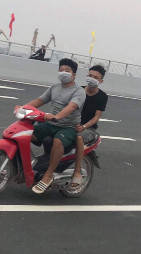 Hai thanh niên đi xe máy, không đội mũ bảo hiểm trên cầu. Ảnh Hải Phòng.