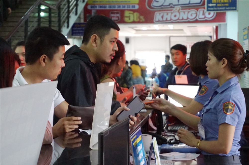 Nhân viên ga Sài Gòn hướng giải đáp thắc mắc của hành khách về việc mua vé tàu Tết. Ảnh: M.Q