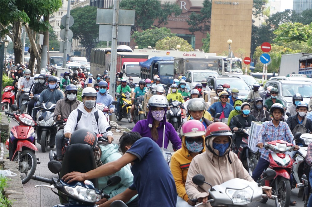 Nhiều người chạy xe máy đua nhau leo lề khiến giao thông thiêm rối loạn.